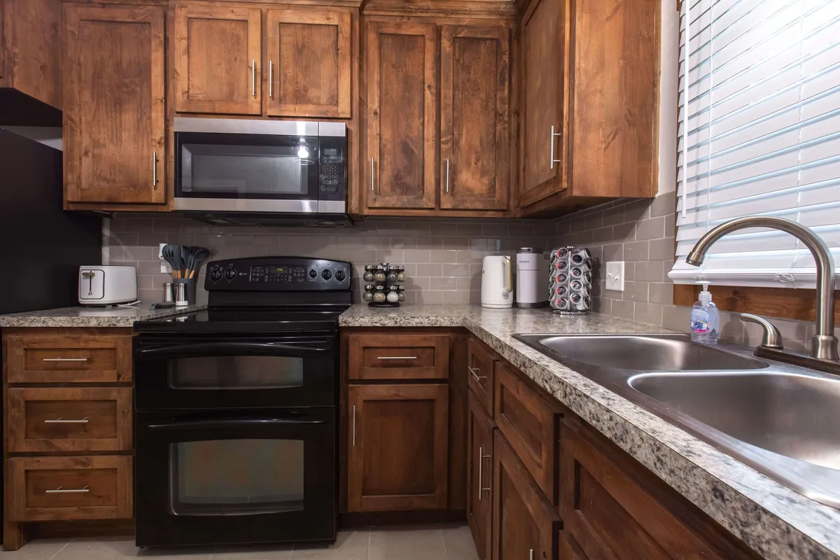 A well-appointed kitchen featuring granite countertops, wooden cabinets, and modern appliances. The warm tones and practical layout invite guests to cook, bake, and socialize comfortably within the heart of the home.